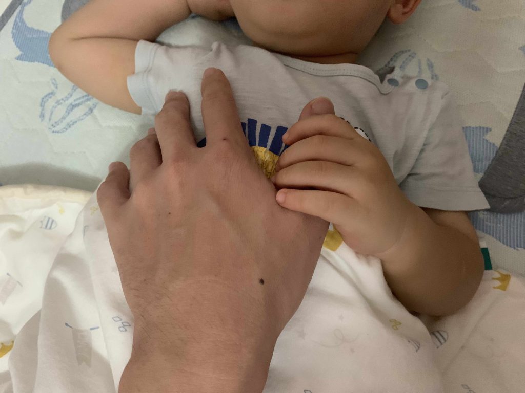 Lucas wants to hold Daddy's hand while patting him to bed...