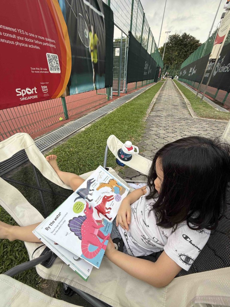 Reading while waiting at Tennis...