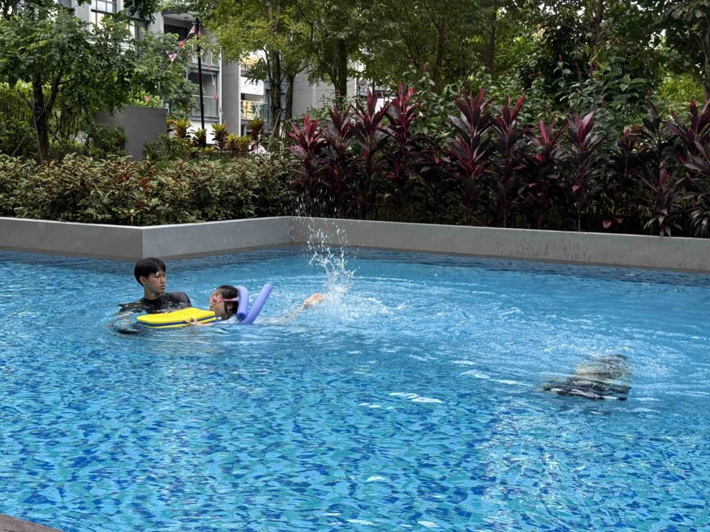 one diving, one learning to kick with board...